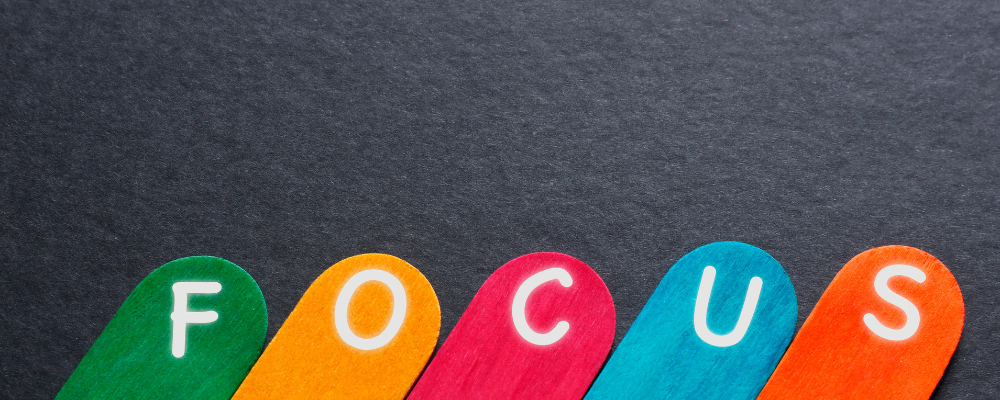 The word focus in bright colors on an off-black background