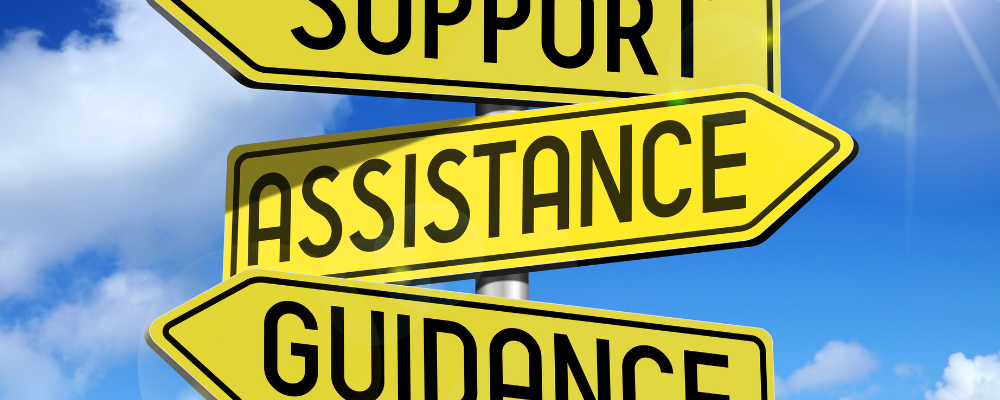 the words support, assistance, and guidance in black letters on yellow street signs