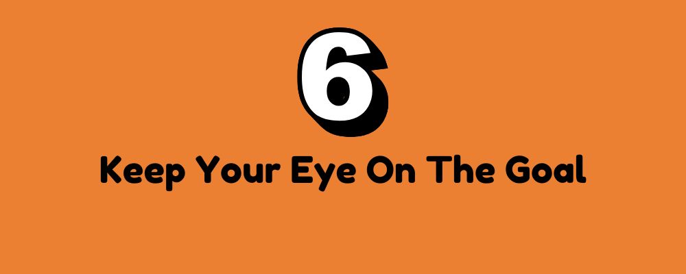 The words "Keep Your Eye On The Goal" in black letters on an orange background